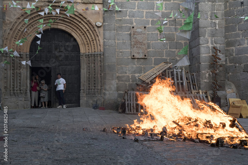 Tableau sur toile Traditional midsummer bonfire burning brightly outside the historic Church of San Juan Bautista during the Night of San Juan festival in Avila, Castile and Leon, Spain
