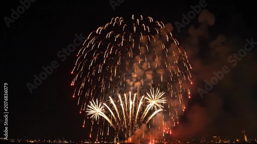 Stunning golden fireworks display lighting up the night sky over a city skyline