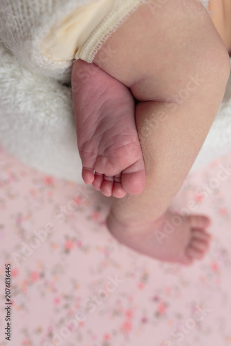 Newborn baby's feet on a pink floral blanket