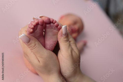 Newborn baby's feet held in mother's hands
