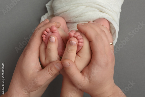 Adult hands holding baby feet