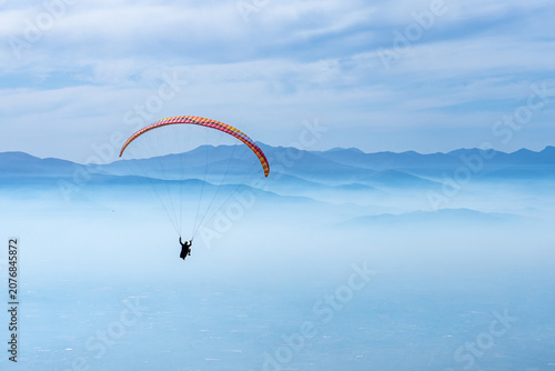 Paragliding over mountains and clouds