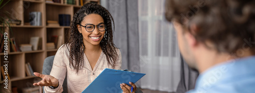 Obraz na plátně Smiling Black Female Therapist Engaging With Male Client During Session In Cozy Office Setting