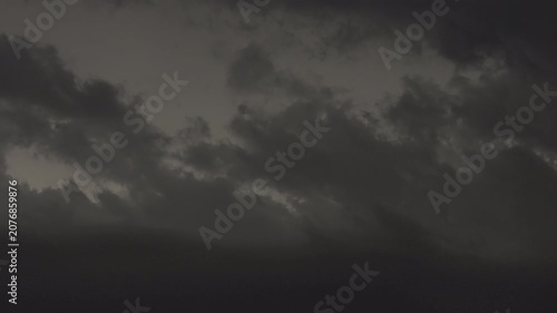 Moody night storm with flashing lightning inside thick clouds