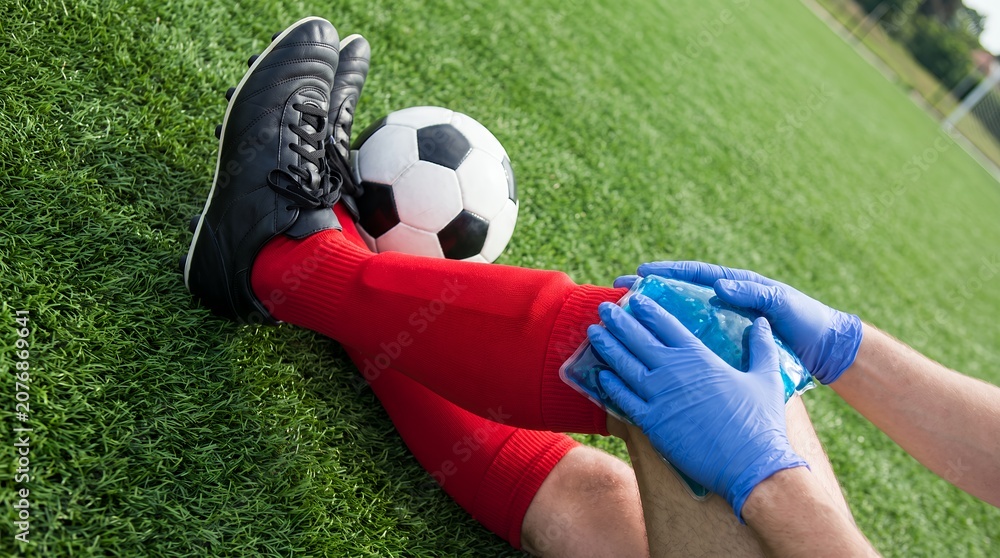 Obraz premium Sports Injury First Aid: Cooling Gel Pack on Football Player Knee