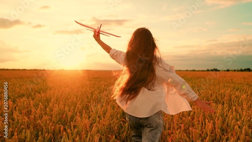 Canvastavla Child girl plays with toy airplane in wheat field