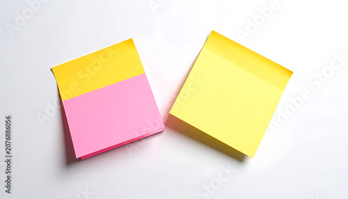 Two square sticky notes in vibrant yellow and pink colors, blank paper for reminders, office supplies, planning, organization, task management
