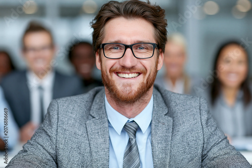 Smiling businessman with glasses in corporate office setting