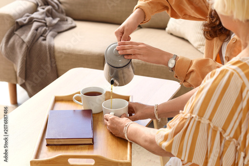Two women pouring tea and r...