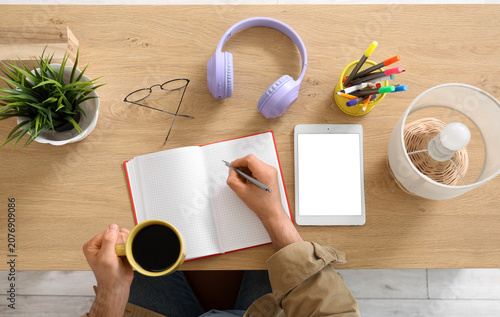 Young man with tablet, cup ...