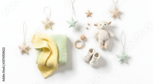 A collection of soft baby essentials and star decorations, including blankets, booties, a lamb toy, and a wooden teether, arranged on a white background.