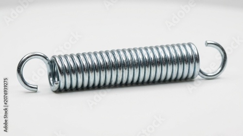 Extension spring in zinc plated steel on white surface macro product Canon EOS R5 100mm macro ISO 100 f/18 1/200s ring flash no people no brands no text no logos