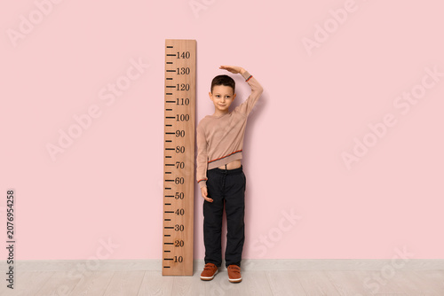 Cute little boy measuring h...
