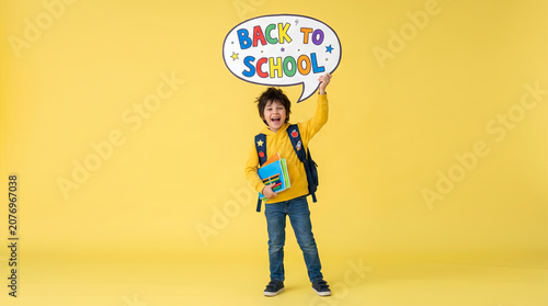 A happy elementary school boy excitedly holding a large comic-style speech bubble 