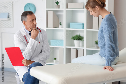 Mature doctor working with patient in medical office