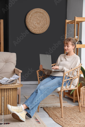 Young woman using laptop in...