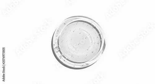 Clear cosmetic gel serum with small particles in circular pattern isolated on white background