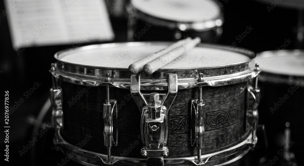 Obraz premium A high-contrast black and white photograph focusing on the geometric rhythm of the tension hoops and the mounting bracket of a tom-tom, 