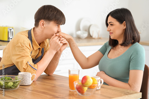 Young man kissing his pregn...