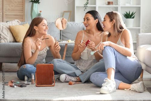 Young women doing makeup at...
