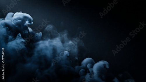 Blue smoke swirling in dark space with mysterious foggy atmosphere