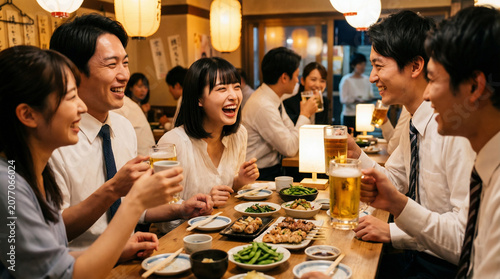 Obraz na płótnie 居酒屋でビールジョッキを持ち大笑いして盛り上がるビジネスグループ