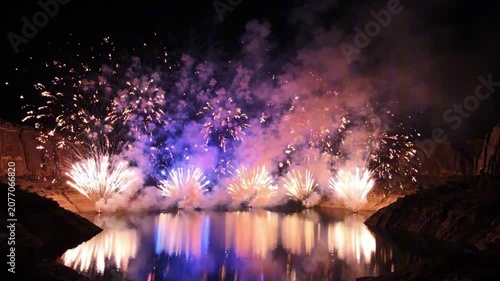 Fireworks illuminate the night sky on USA Independence Day celebration by a serene lake