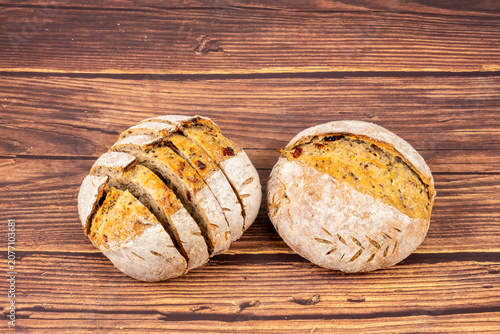 Freshly baked sourdough bread loaf on the wooden and white background with full depth of field. Artisanal or healthy food concept