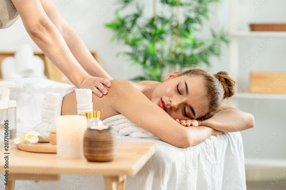 Naklejka premium Beautiful woman getting back massage treatment with oil at beauty spa.