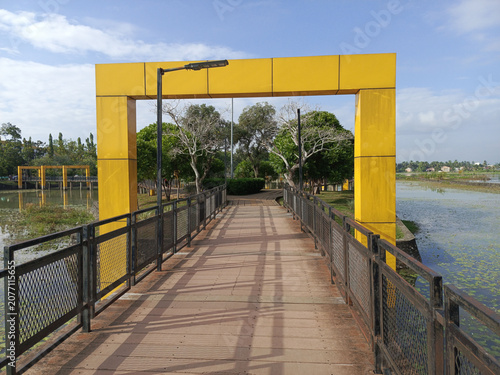 Yellow bridge over water with walkway.