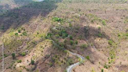 Beautiful aerial view of Wilson Hills located in Gujarat- India, A high-resolution aerial drone photograph of a winding mountain road featuring multiple hairpin bends through a dry deciduous forest