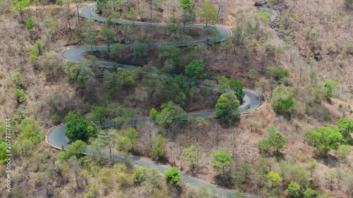 Beautiful drone view of Wilson Hills located in Gujarat-India, A high resolution aerial drone photograph of a winding mountain road featuring
multiple hairpin bends through a dry deciduous forest