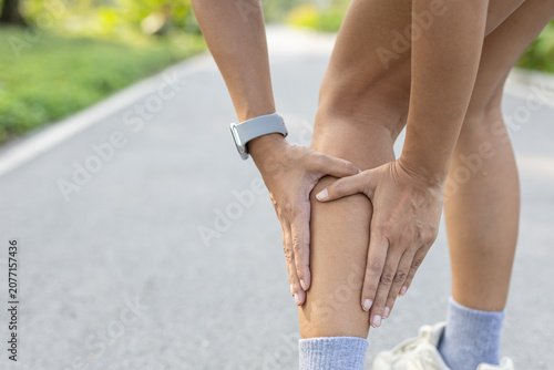 Foto Runner woman with leg pain from muscle cramp or injury during outdoor exercise
