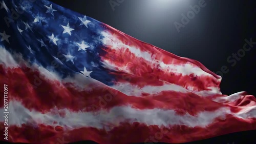 The American flag waves proudly on USA Independence Day in a dark room with spotlight.
