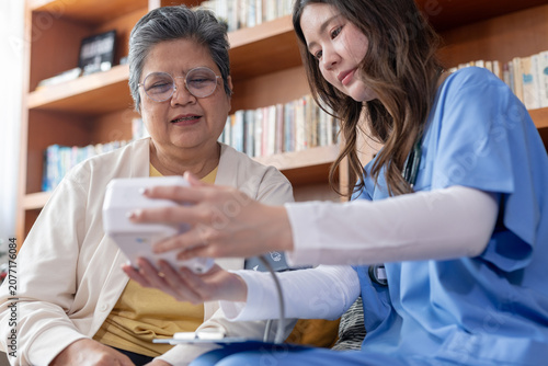 Quadro su tela Caring asian caregiver nurse provides home care for senior patient