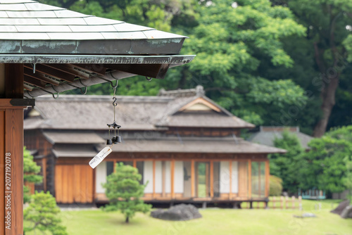 Japanese wind chime hanging from traditional roof eave with wood