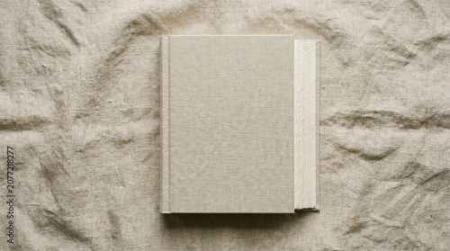 Closed linen book on wrinkled fabric background