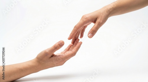 One hand reaching downward toward an open upturned palm on white backdrop