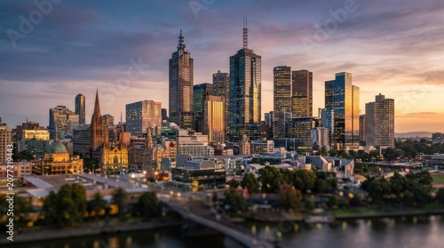 Melbourne Skyline at Dusk: A panoramic view of the Melbourne cityscape at twilight, showcasing iconic skyscrapers illuminated against a vibrant, colorful sky, with a river flowing in the foreground.