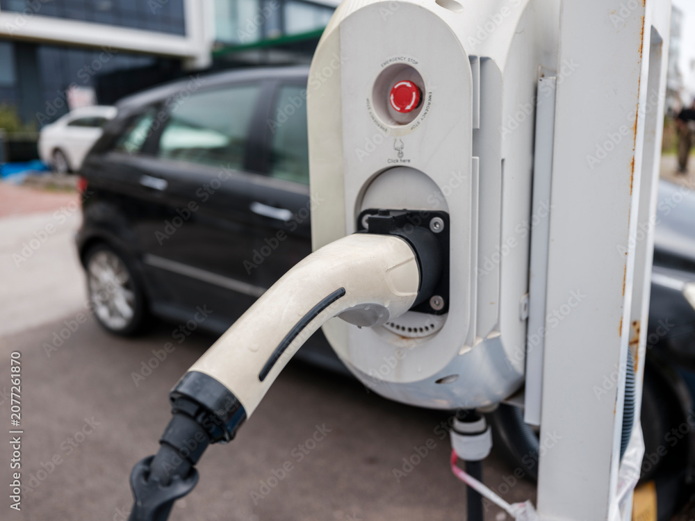 Fototapeta premium Electric vehicle charging station close-up in parking lot