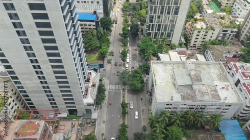 City Street Aerial View with Tall Buildings, Trees, and Traffic Showing Urban Planning and Daily Commuting Ambiance