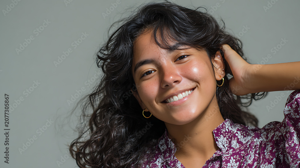 Fototapeta premium close up portrait of happy woman with curly hair smiling genuinely wearing hoop earrings perfect for beauty marketing haircare advertising and cosmetic brand content