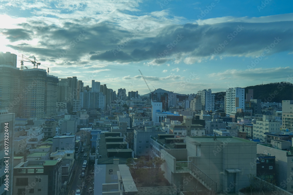 Naklejka premium View of the city seen through a window. Urban landscape framed by glass, concept of home, everyday life, travel, and modern city living