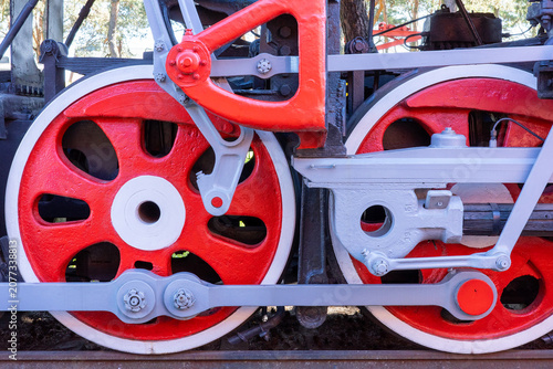 Fotografie This close-up shot highlights the intricate mechanical assembly of a vintage steam locomotive's driving wheels and connecting rods