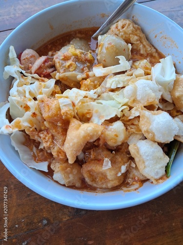 Spicy Indonesian Noodle Soup with Meatballs, Tofu, Egg, Cabbage, and Crackers in a Bowl
