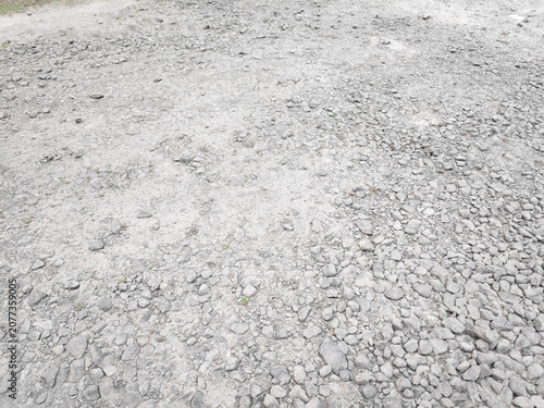 Foto Daylight illuminates a rough textured surface made of countless uneven grey pebb