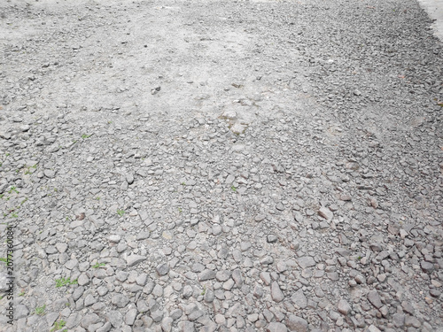 Slika na platnu Daylight illuminates a rough textured surface made of countless uneven grey pebb