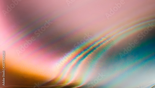 Abstract iridescent light reflection with rainbow colors on curved metallic surface