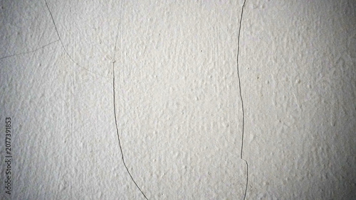 Foto Clean white plaster wall with multiple thin hairline cracks running vertically