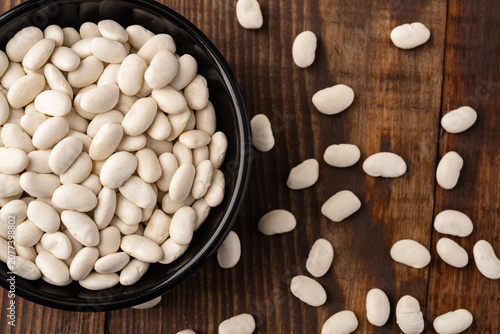 Uncooked white beans on a wooden background